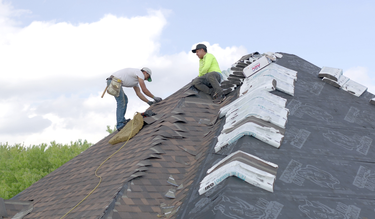 two men on a house roof working on roof restoration
